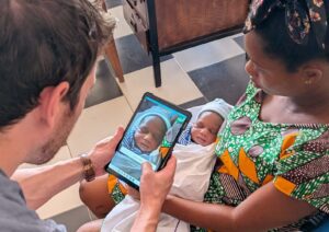 Man taking a biometric image of a sleeping baby via the Simprints app